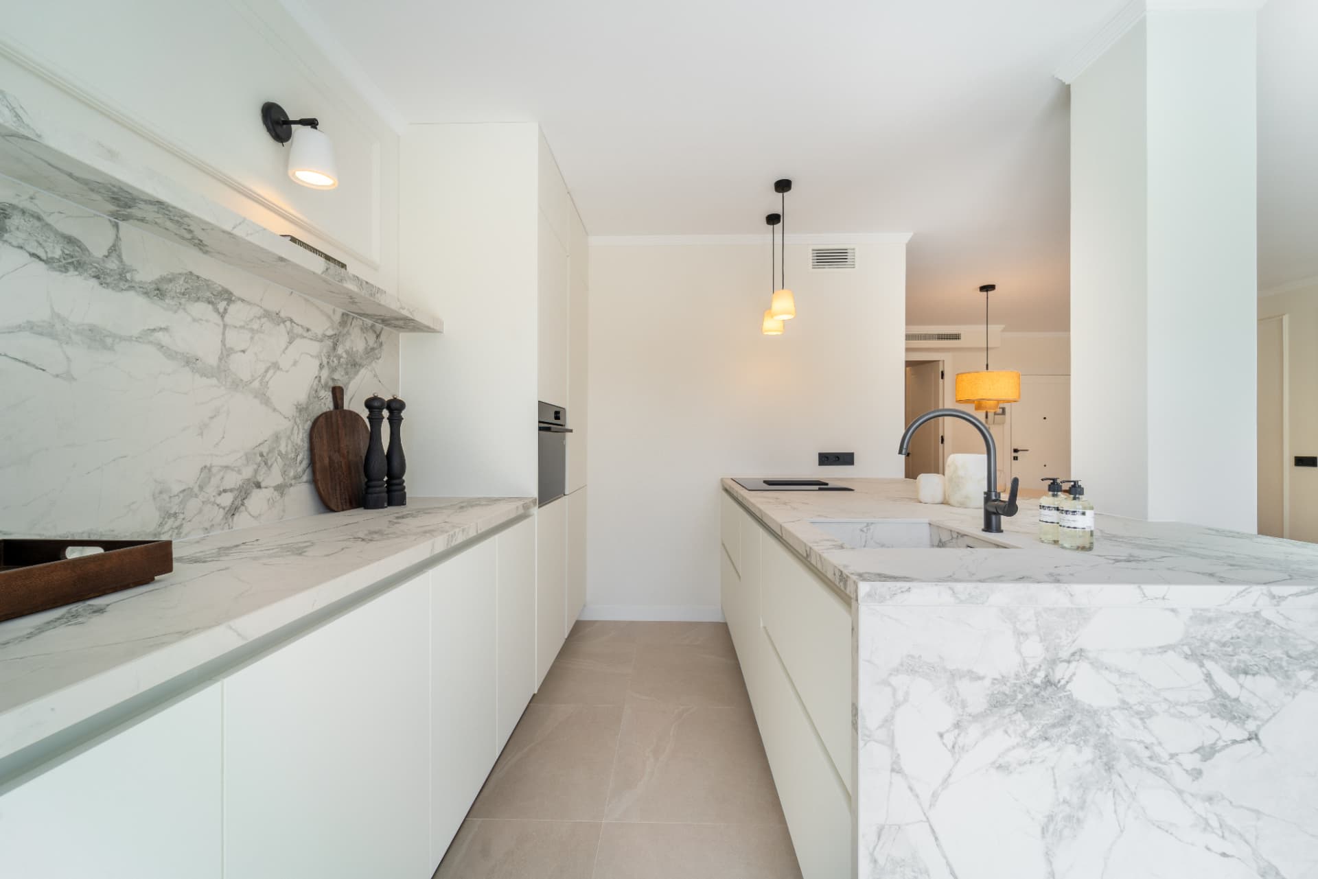 Kitchen with marble worktops and white cabinetry
