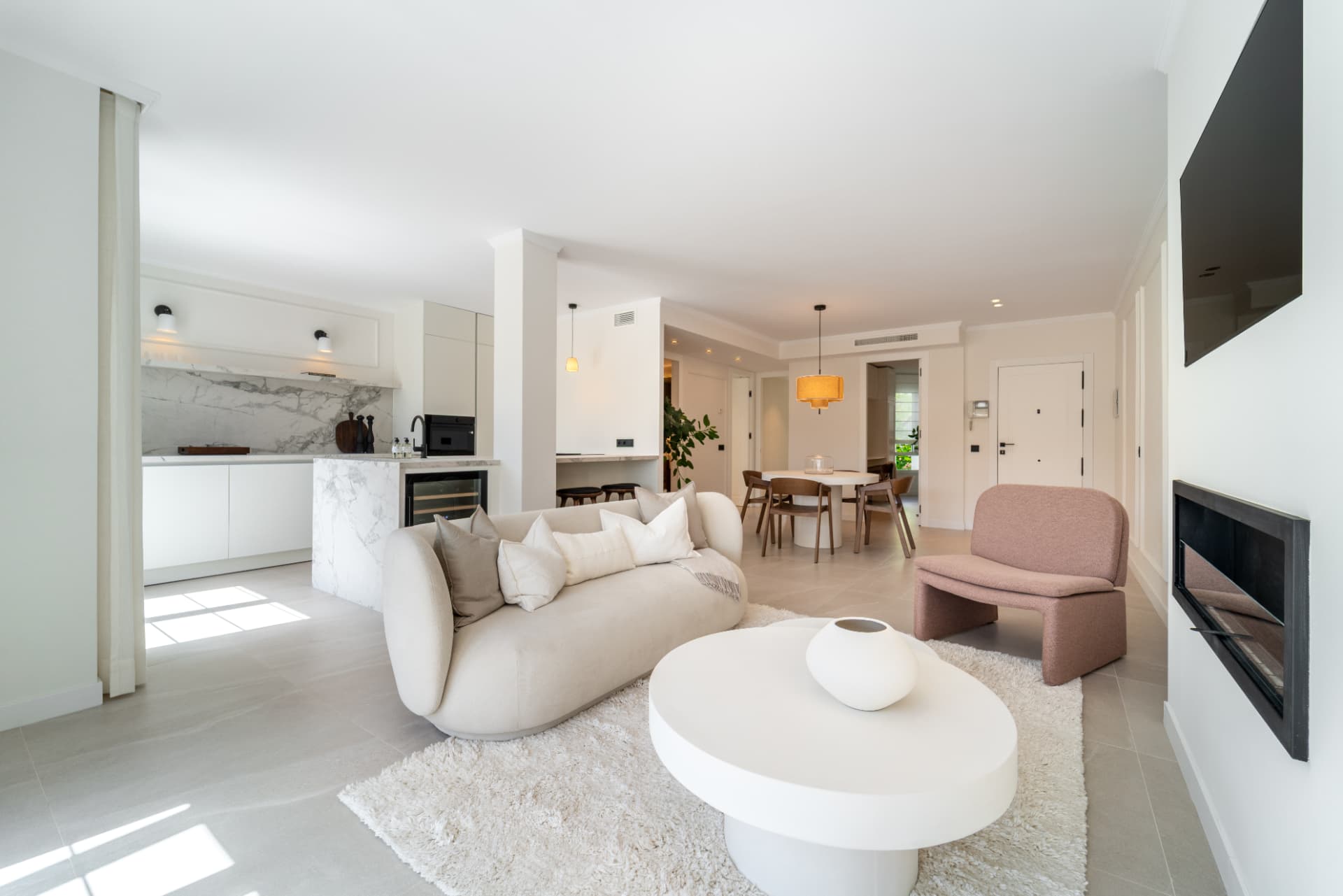 Living room with cream sofa, fireplace and doors to the terrace