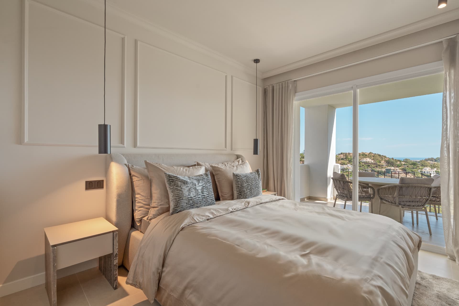 Bedroom with upholstered headboard and doors to the terrace