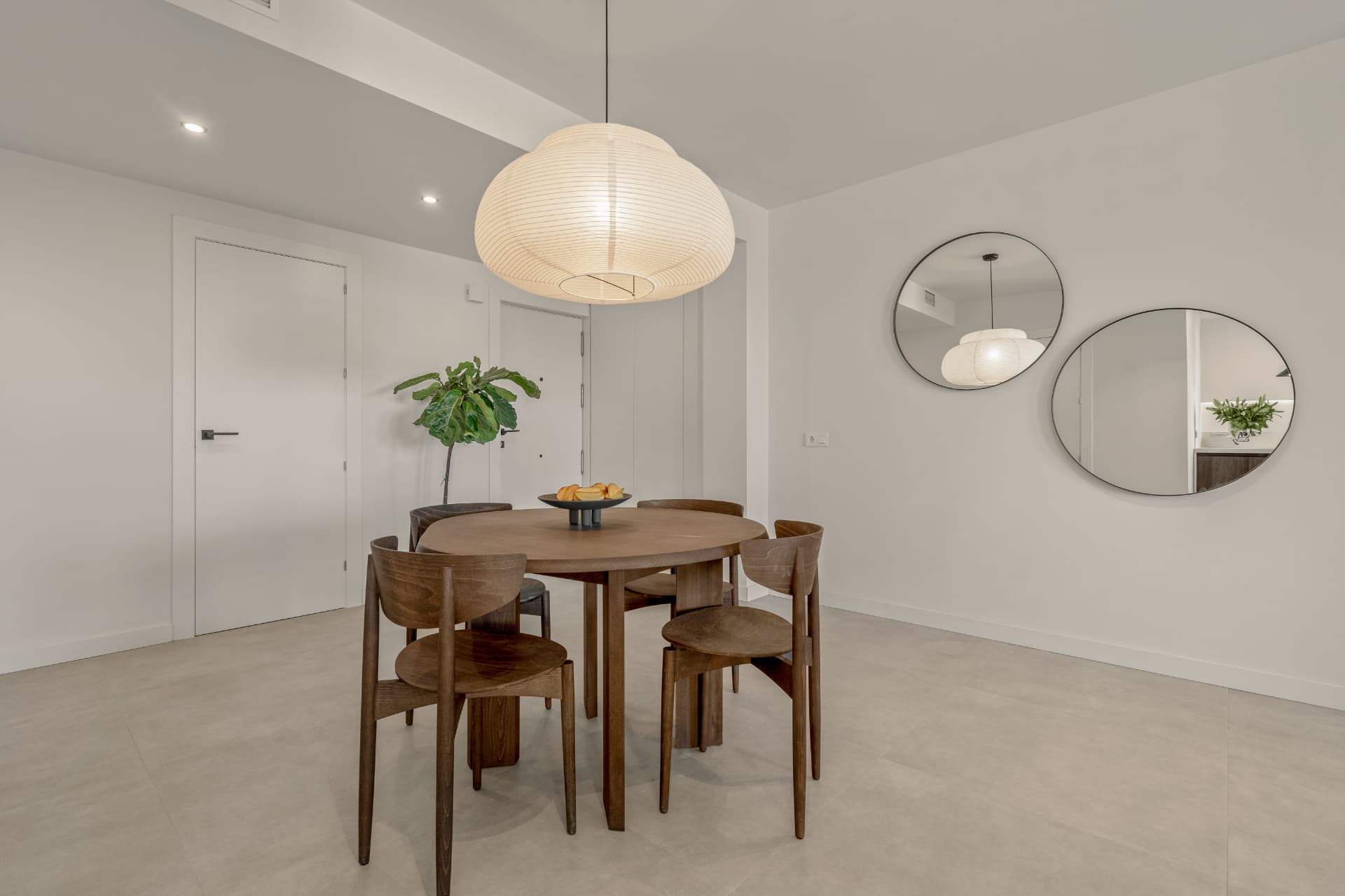Dining area with round oak table and wall mirrors