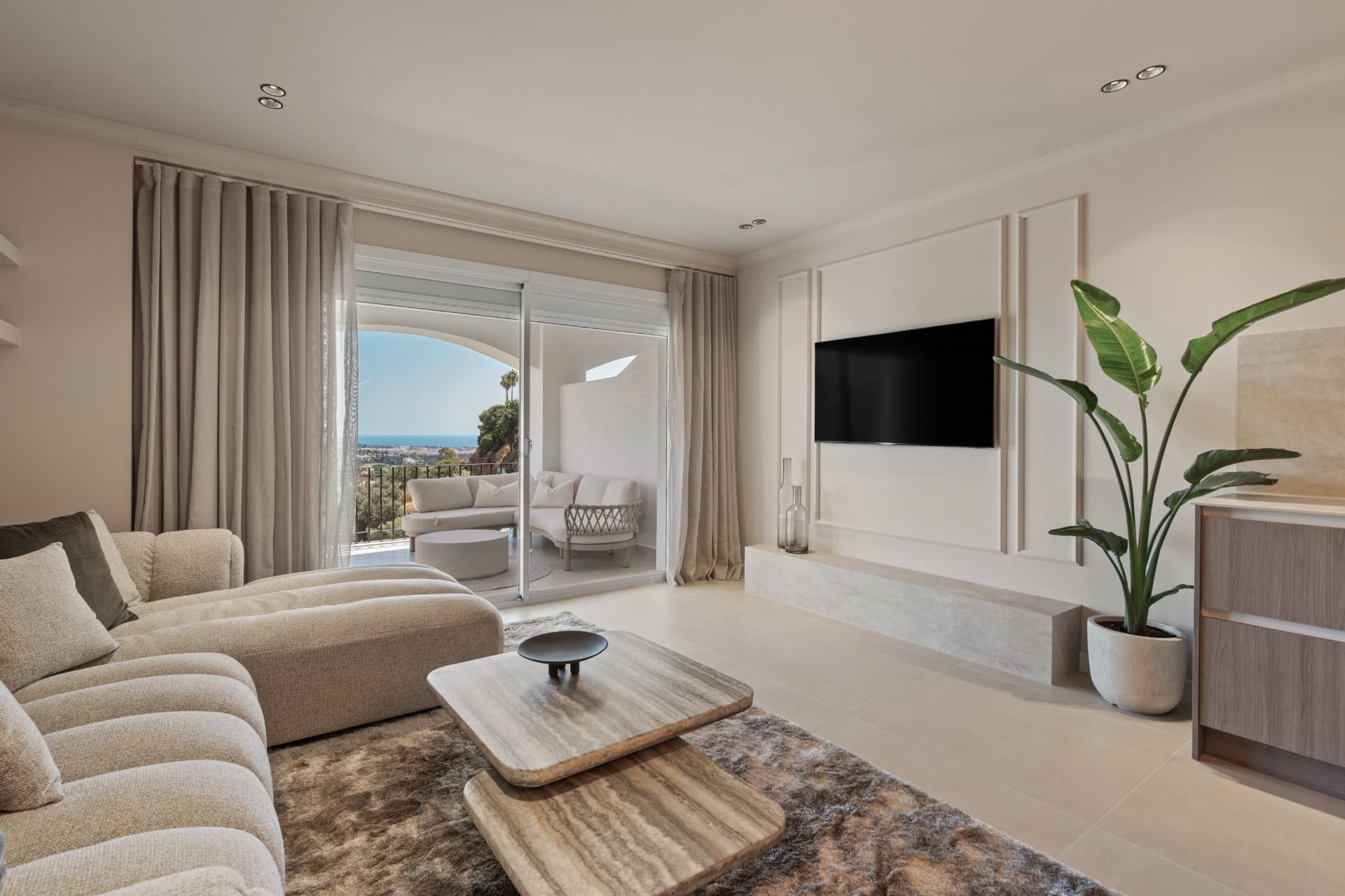 Living room with television wall and view towards the terrace