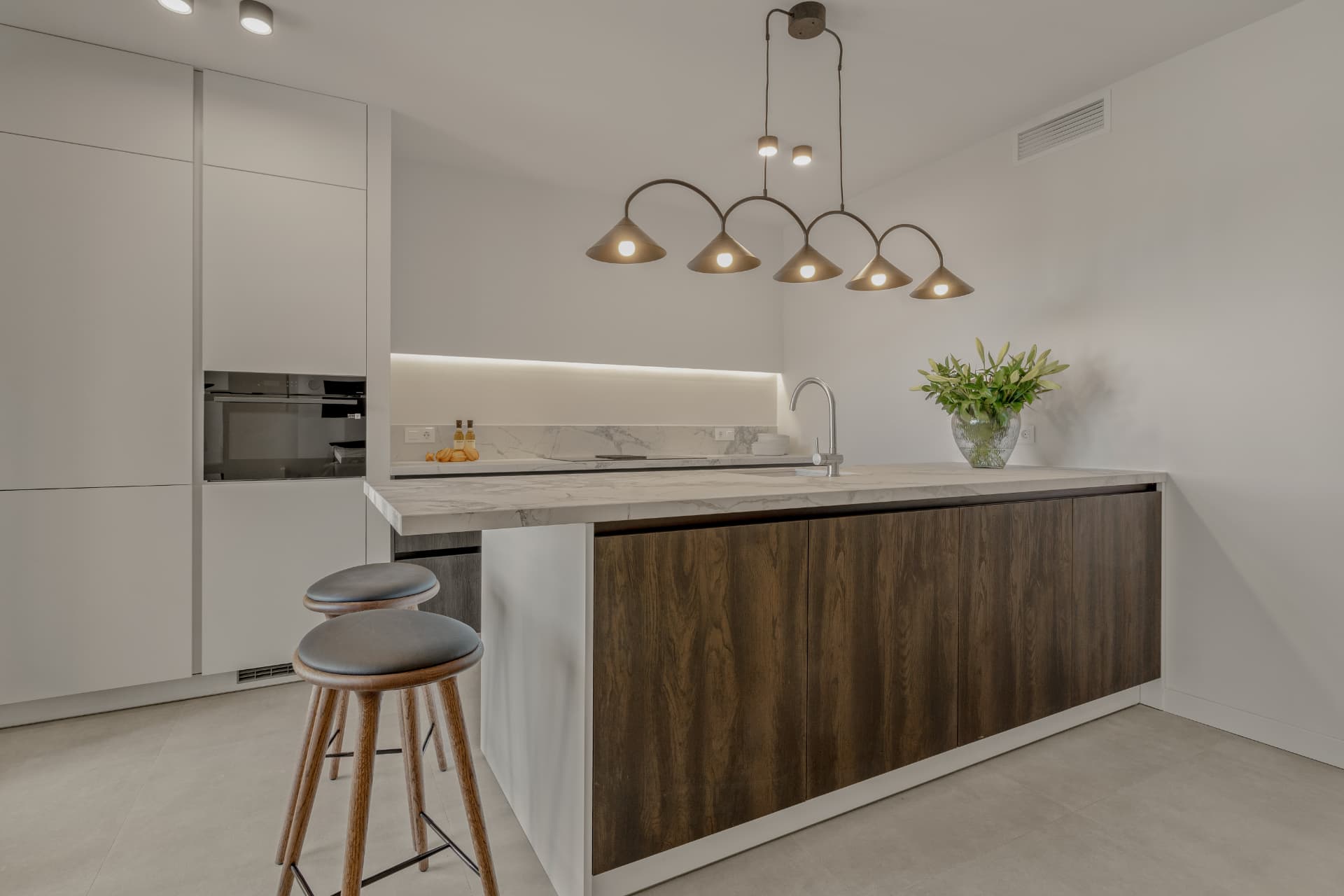 Kitchen with island, marble worktop and dark oak fronts