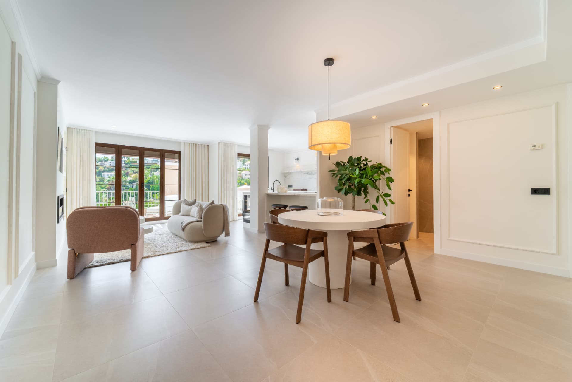 Dining area with round white table and wooden chairs