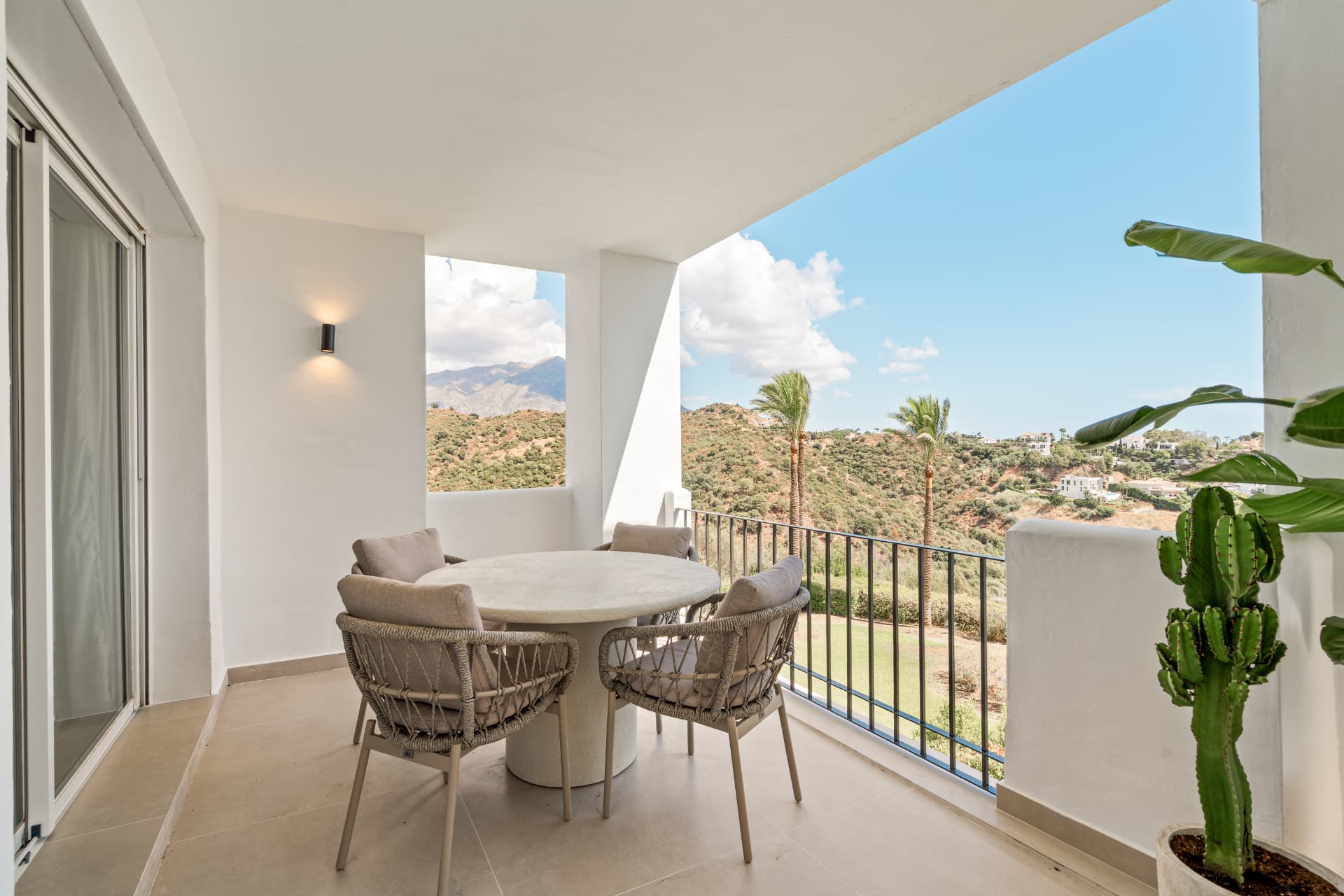 Covered terrace with dining table and views over the hills