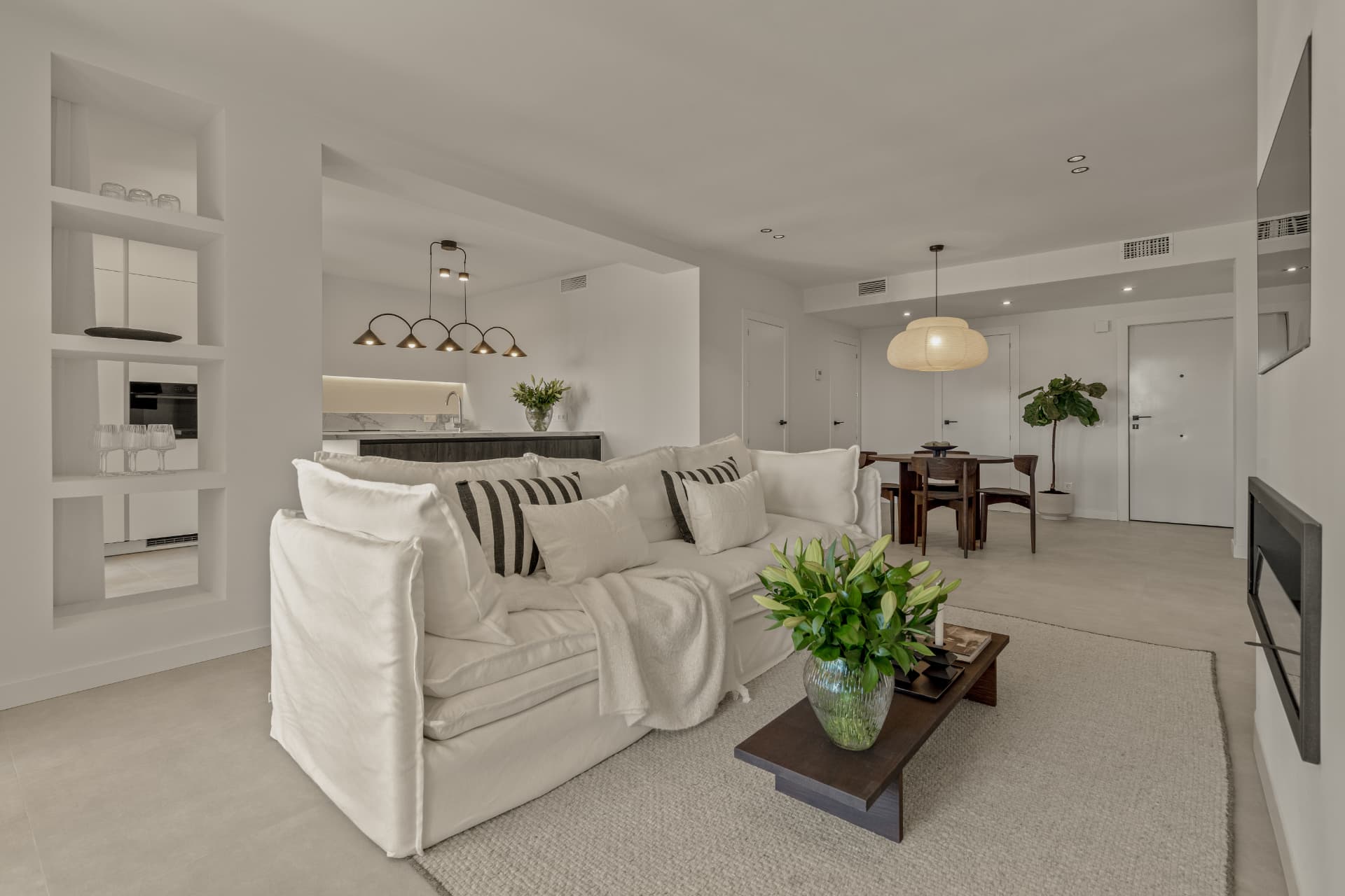 Living room with white sofa and open kitchen behind