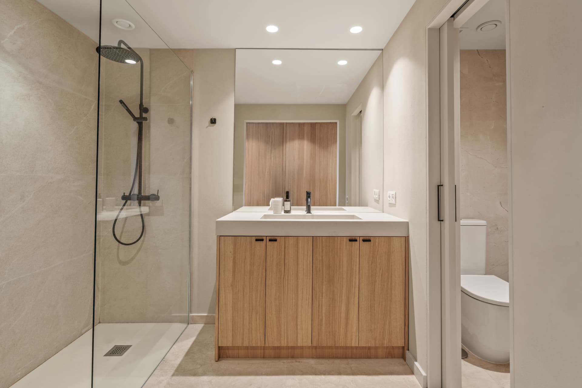 One of the bathrooms: an oak vanity with an integrated basin, a walk-in shower beside it