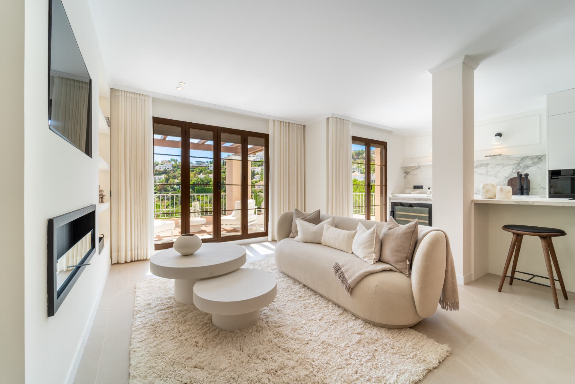 Living room with television above the fireplace and views outside