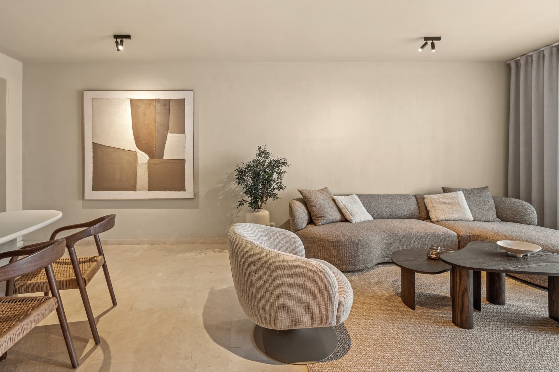 The lounge after the renovation: a curved sofa, framed art and the dining table beyond