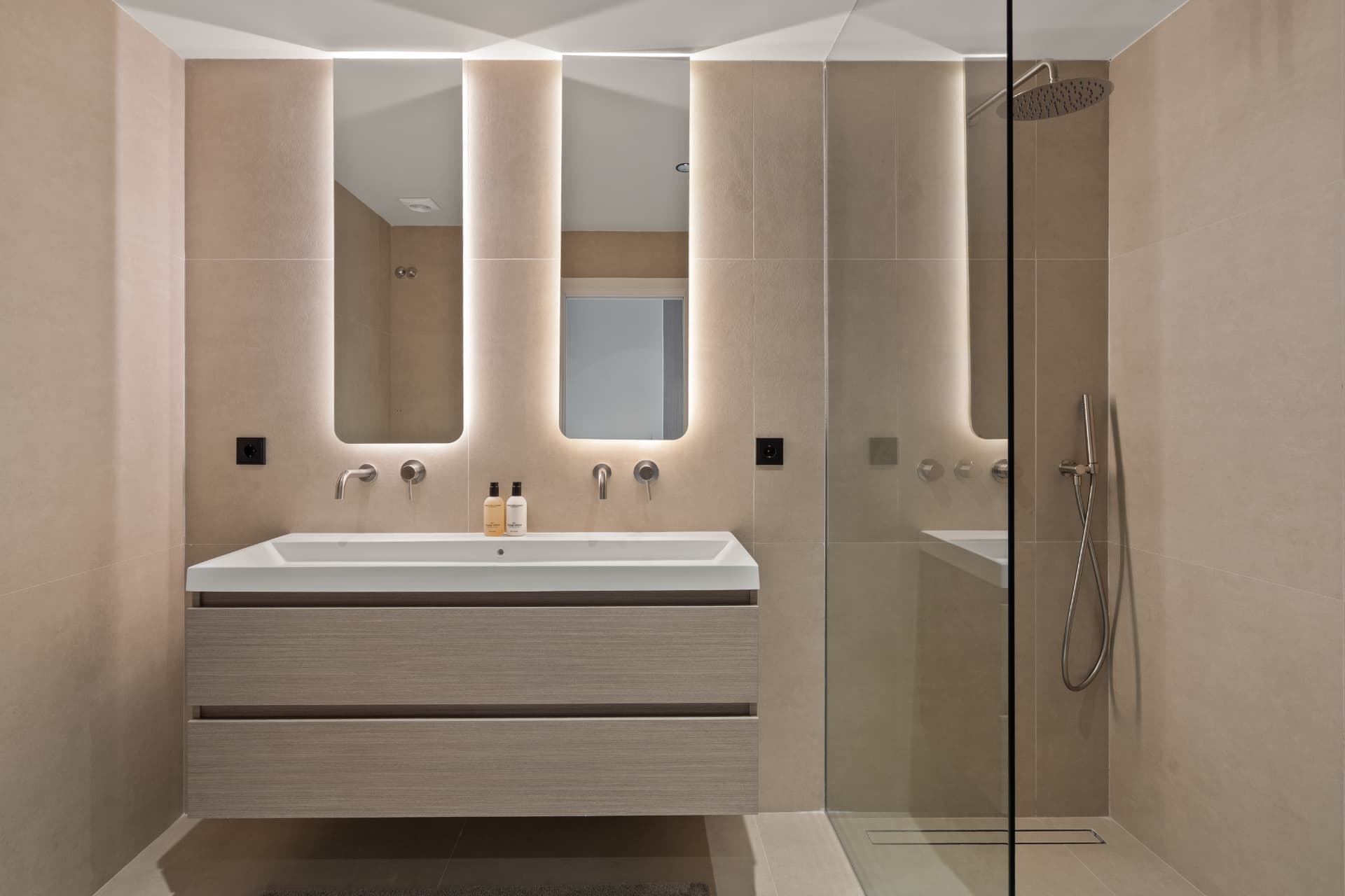 Bathroom with walk-in shower, double basin and backlit mirrors