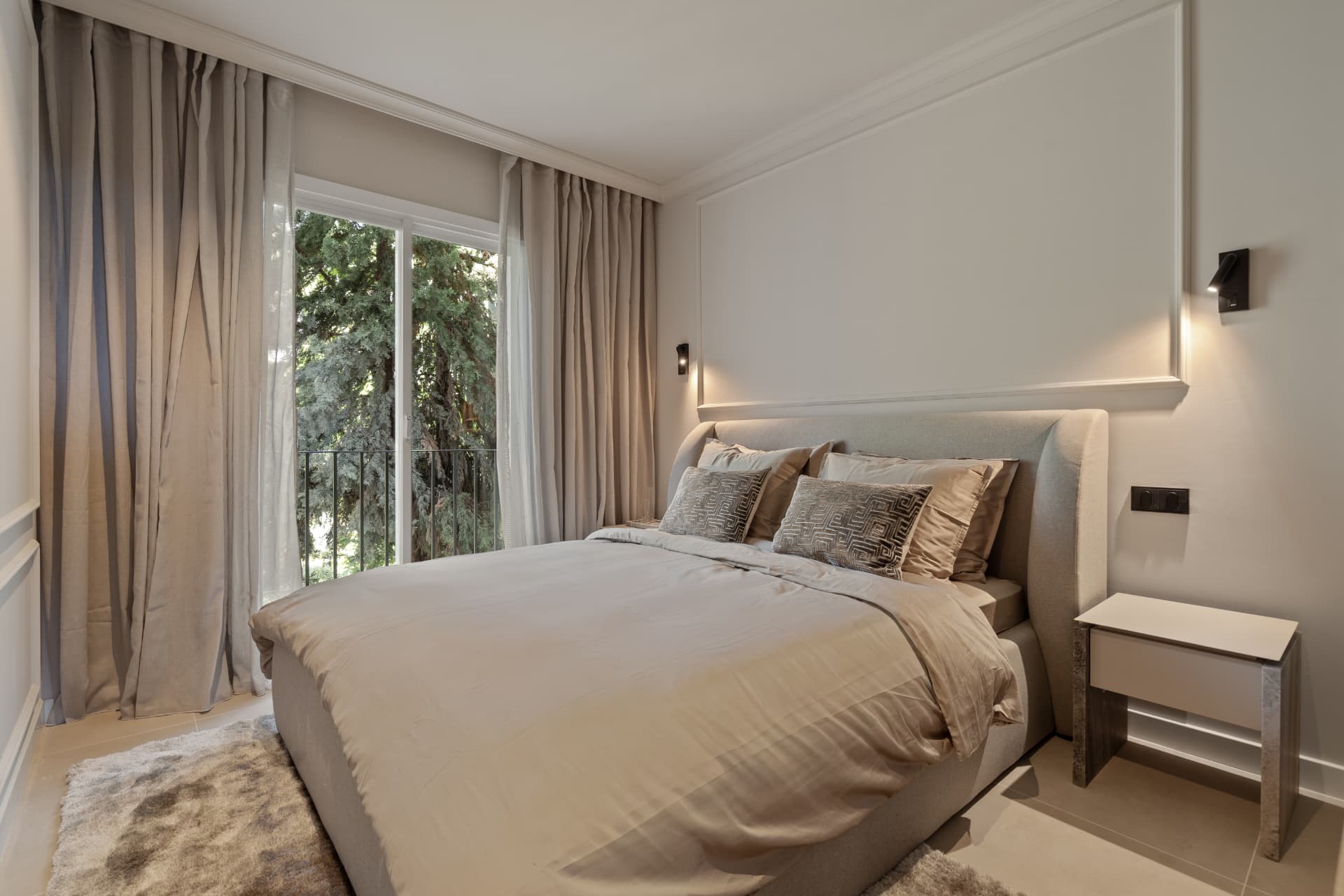 Bedroom with full-height curtains opening to the garden