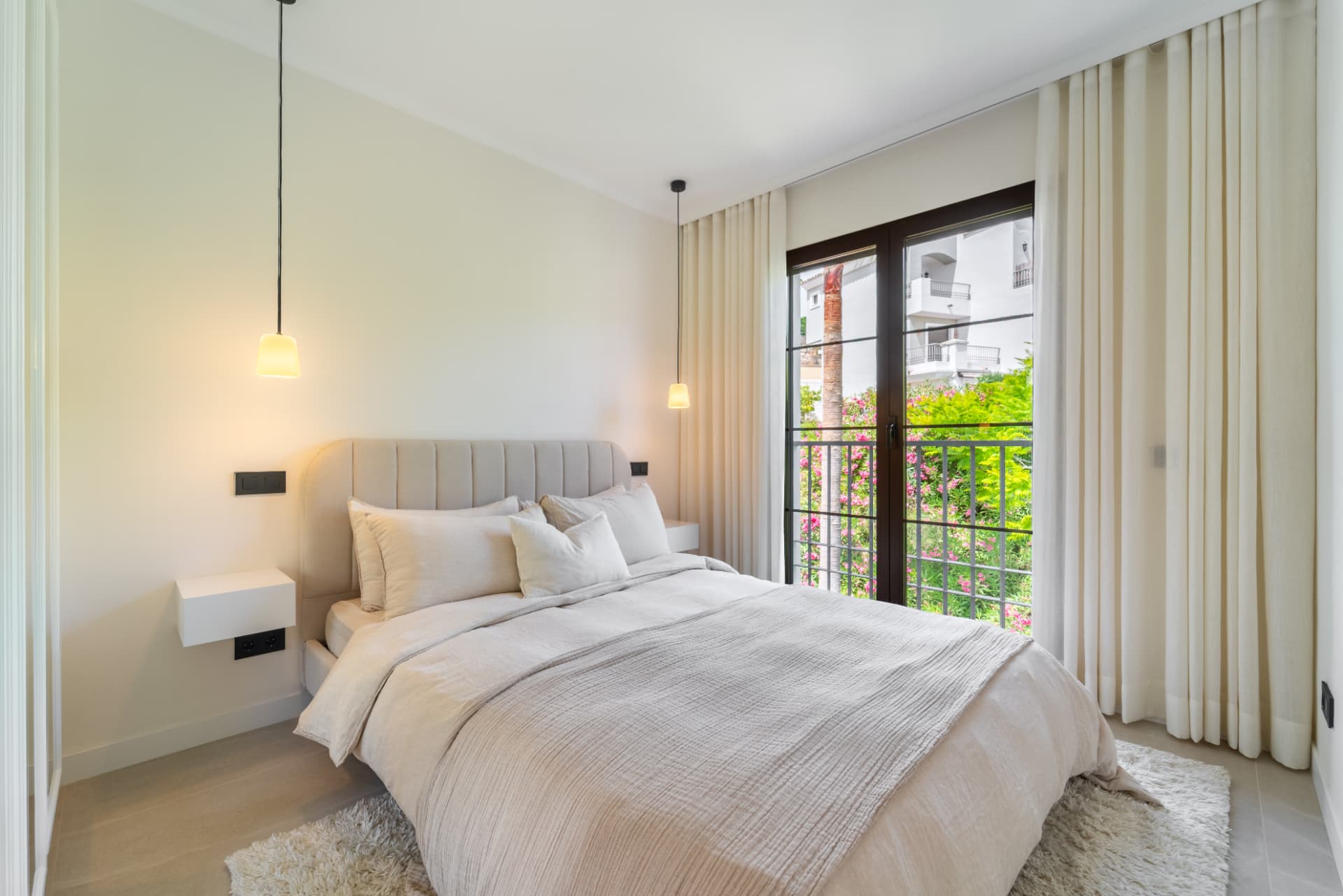 Bedroom with pendant lights and doors to the garden