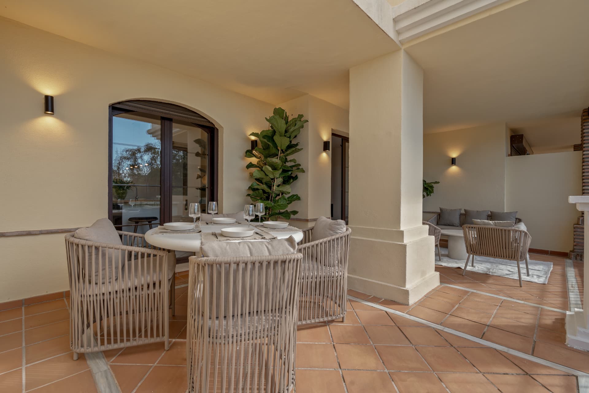 Covered terrace with outdoor dining table and lounge corner